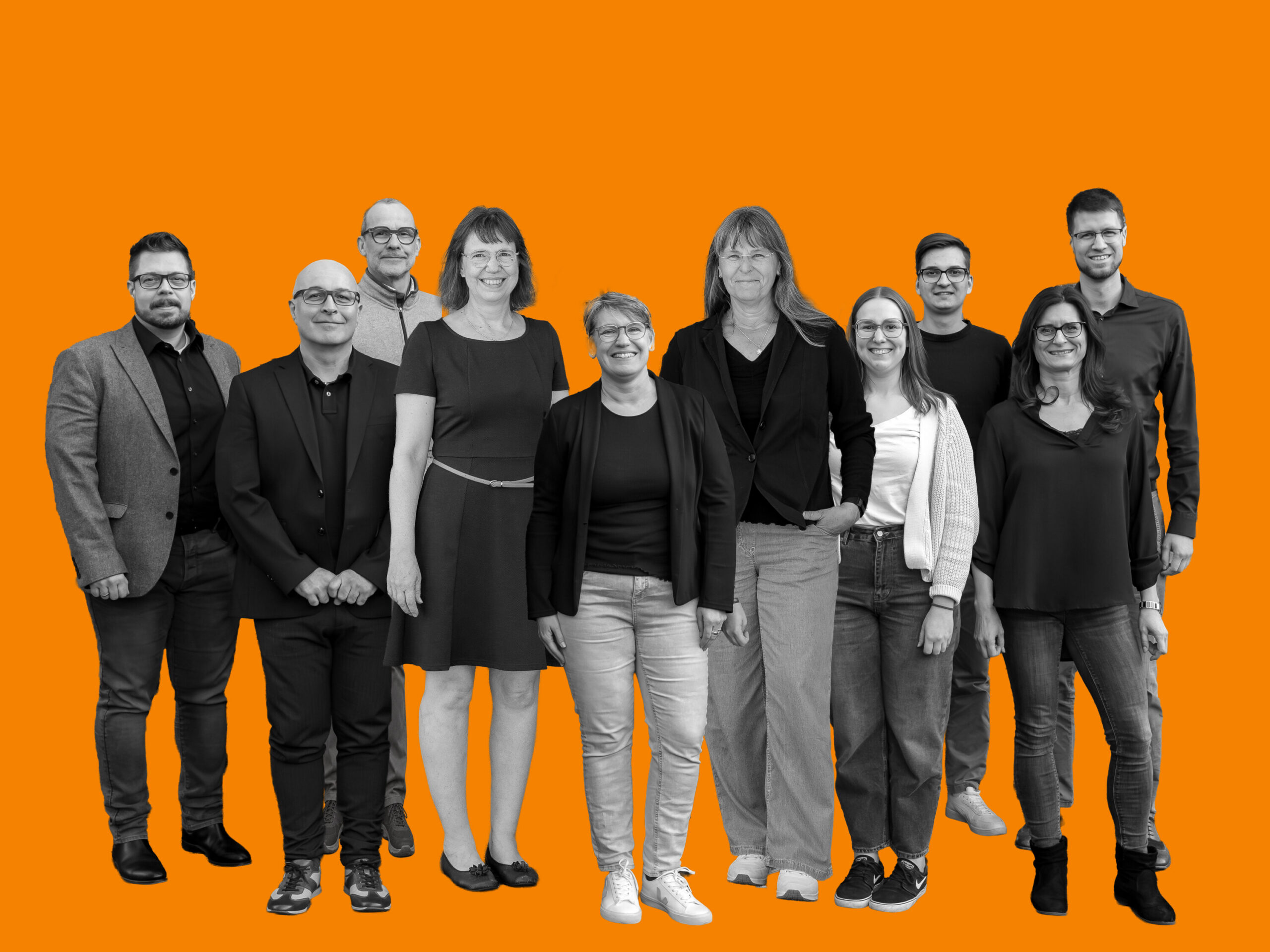 Zehn Mitglieder des Teams von Brillen Krug in zwei Reihen vor orangefarbenem Hintergrund.